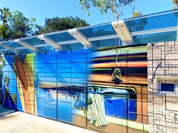 A bathroom with a colorful mural on the side of it